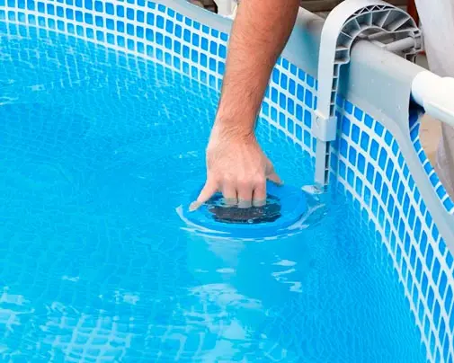 Profissional da Manancial fazendo a manutenção e limpeza da piscina